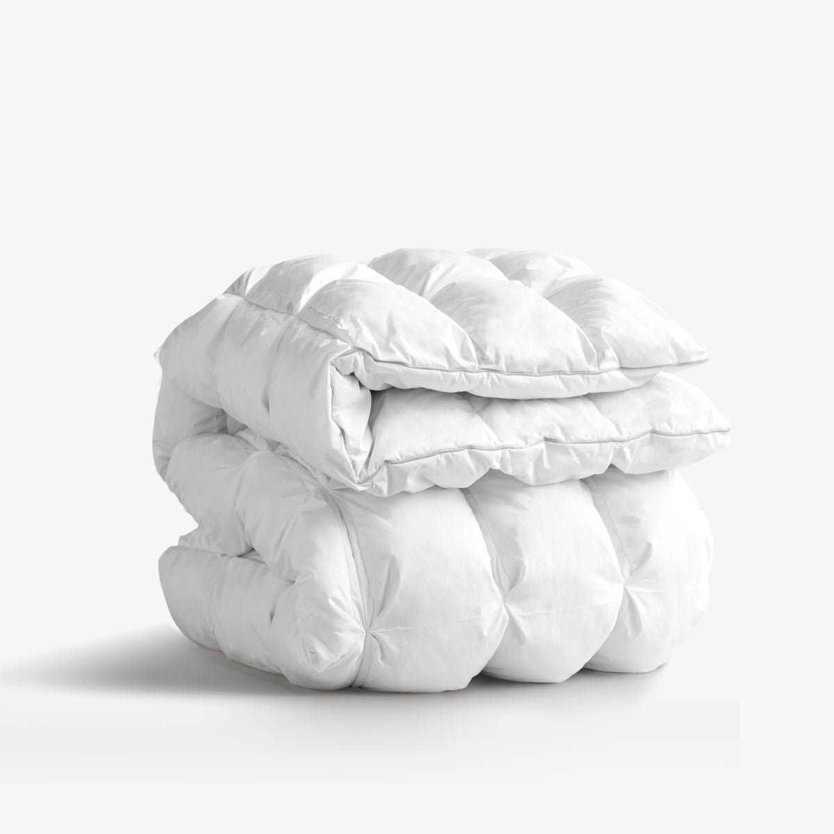 A neatly folded white duvet with a quilted design on a plain background.